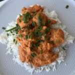 tempeh meatballs in roasted peppers sauce - on plate with rice