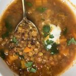 brown lentil soup on and a spoon