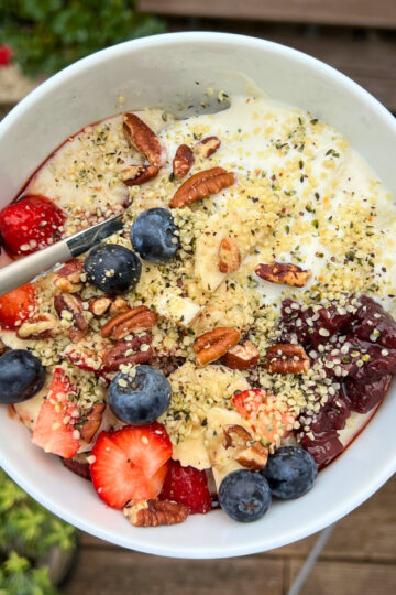 Cozy Morning Porridge Bowl with yoghurt, fruits, jam, hemp seeds, pecans, date syrup