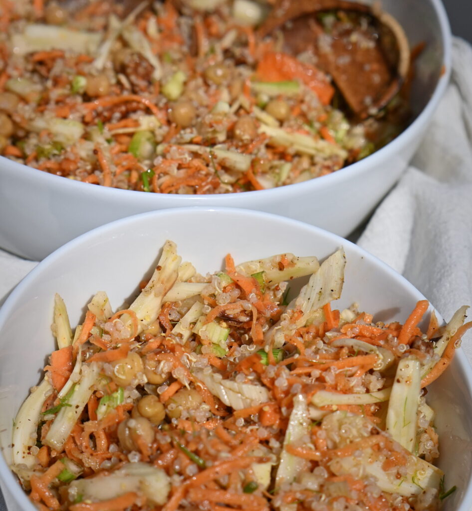 a serving bowl and small bowl with carrot and fennel salad on a table with white cloth