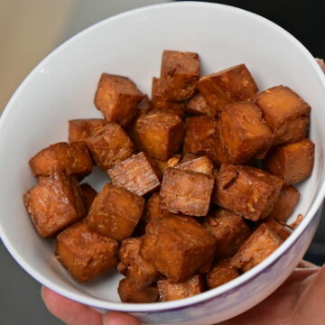 a white bowl with smoked tofu cubes