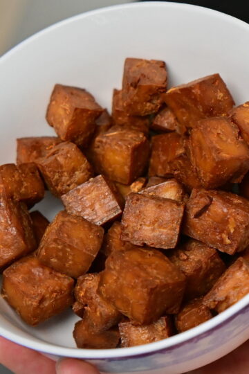 a white bowl with smoked tofu cubes