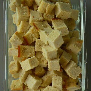 glass container with almond feta cubes