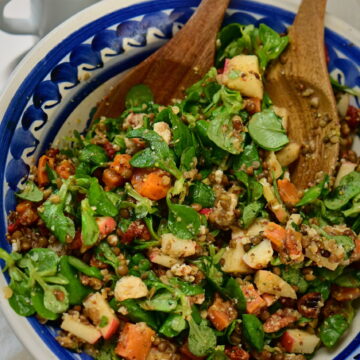 brown lentils and sweet potato salad with wooden spoons and blue bowl