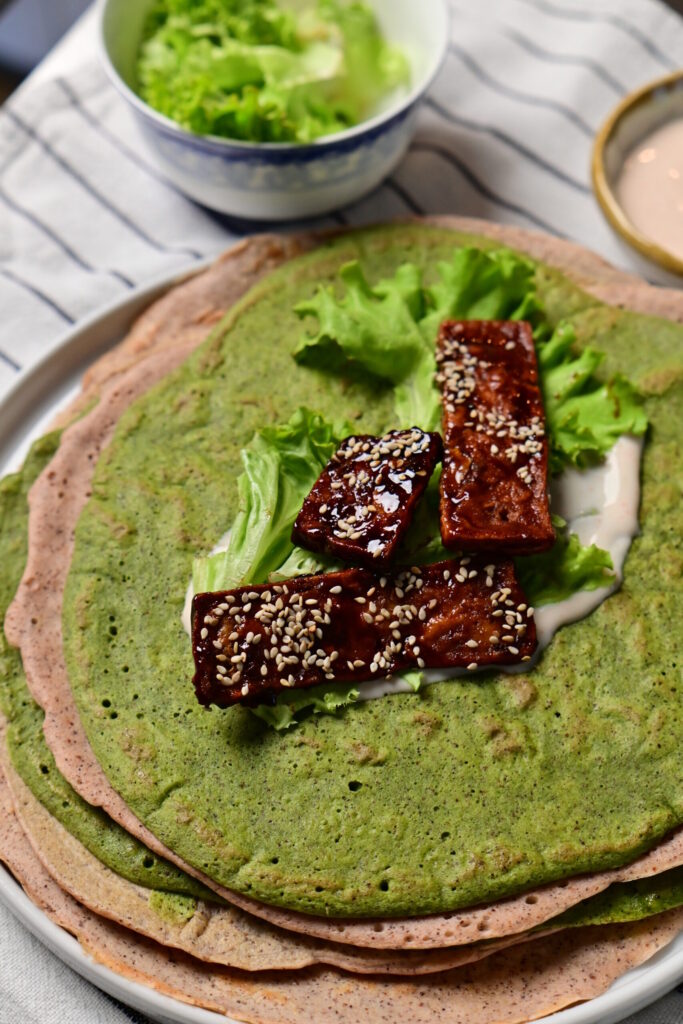 sticky tofu on green gluten free wraps with lettuce and vegan spread