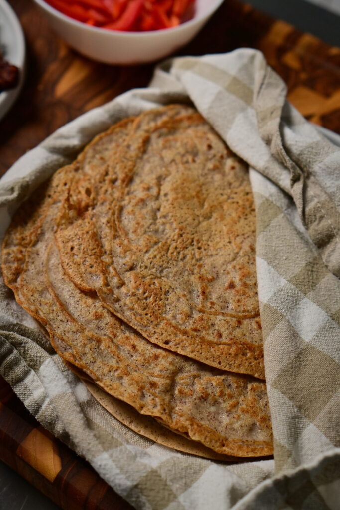 quinoa and red lentils wraps in a towel on wooden board