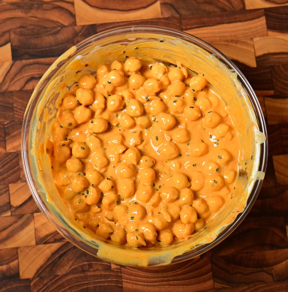 yoghurt Curry Chickpeas in a glass bowl on wooden board