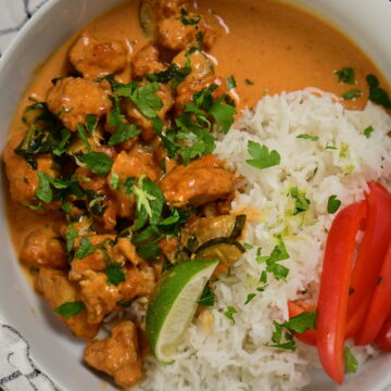 a bowl with coconut lime tofu with herbs, with basmati rice and red bell peppers, topped with herbs and lime zest