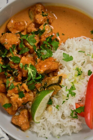 a bowl with coconut lime tofu with herbs, with basmati rice and red bell peppers, topped with herbs and lime zest