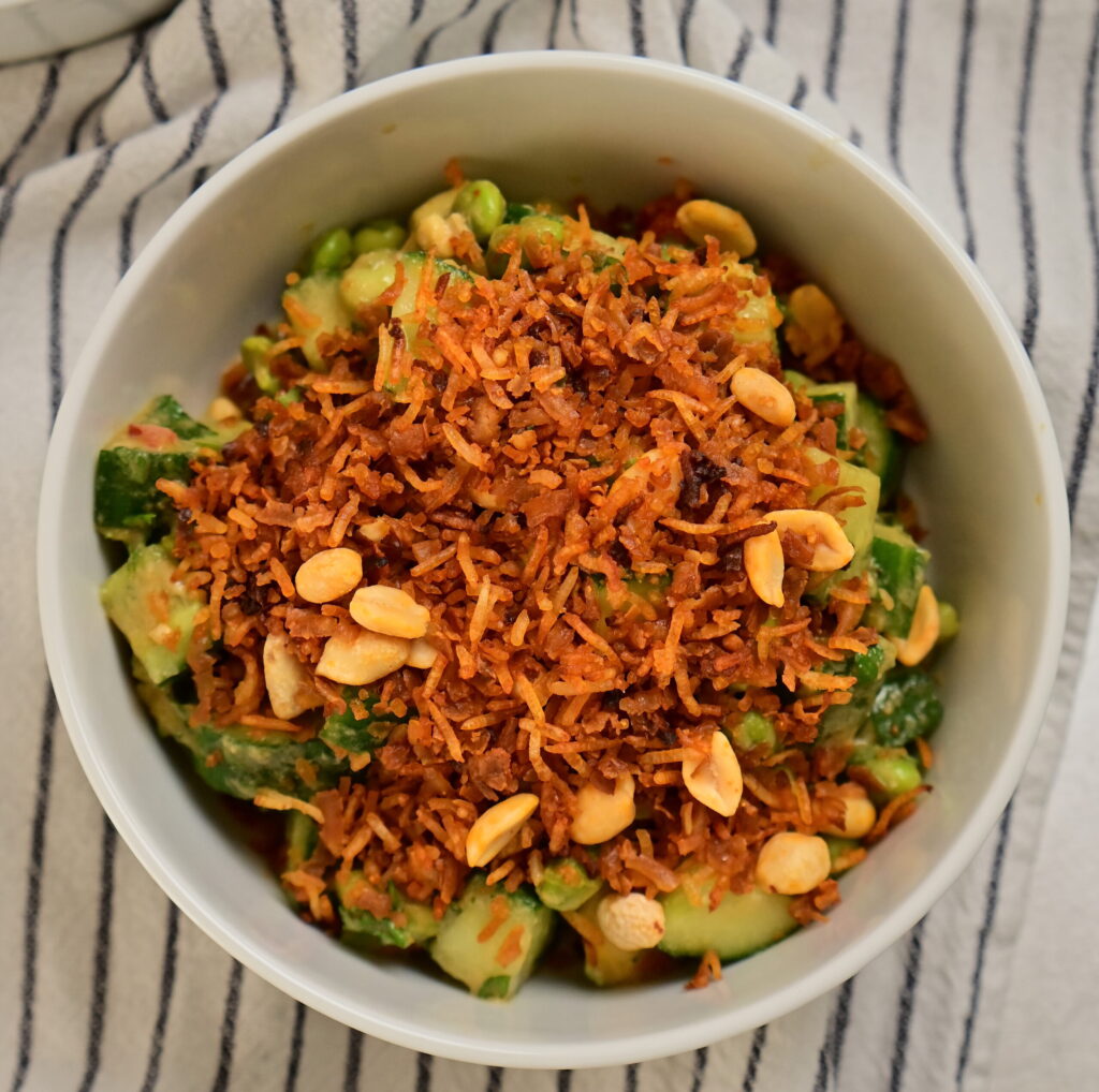 Thai-style crispy rice salad in a white bowl on a striped tablecloth