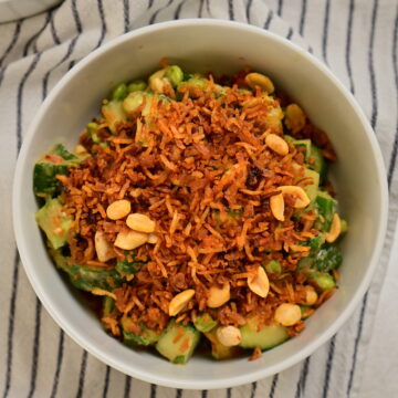 Thai-style crispy rice salad in a white bowl on a striped tablecloth