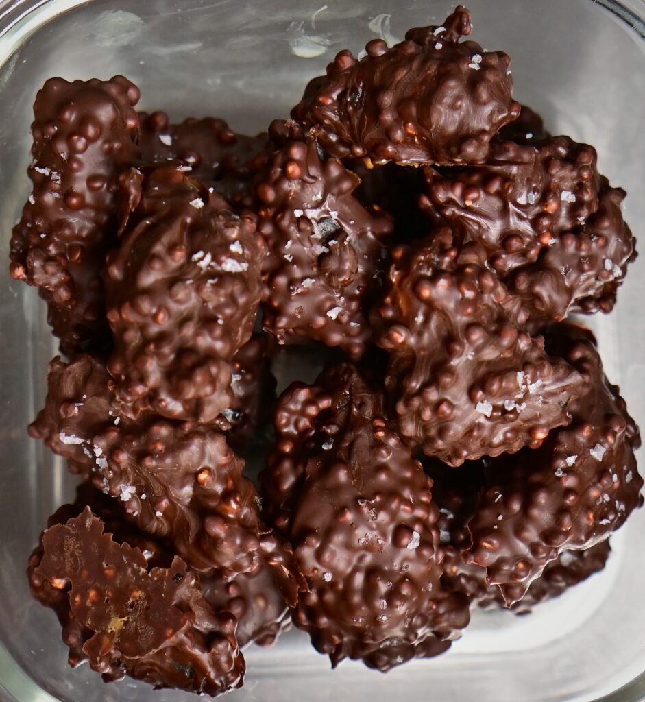 fancy stuffed dates covered in chocolate in a glass container
