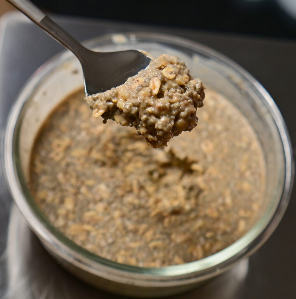 over night oats with chia seeds with a spoon in a jar container
