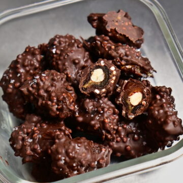 fancy stuffed dates covered in chocolate in a glass container