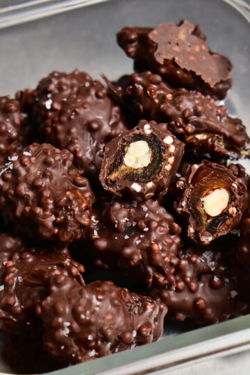 fancy stuffed dates covered in chocolate in a glass container