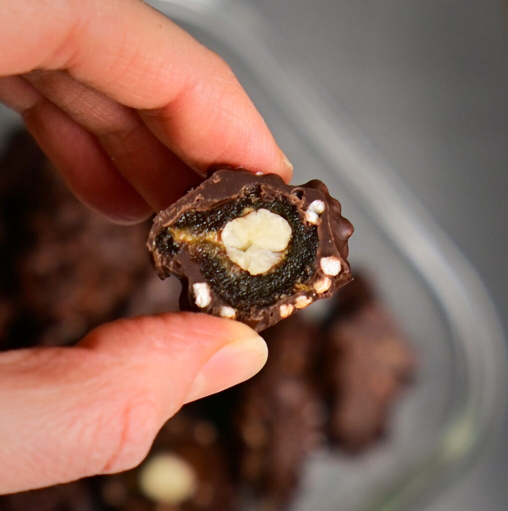 halved stuffed date covered in chocolate with peanut butter and hazelnut