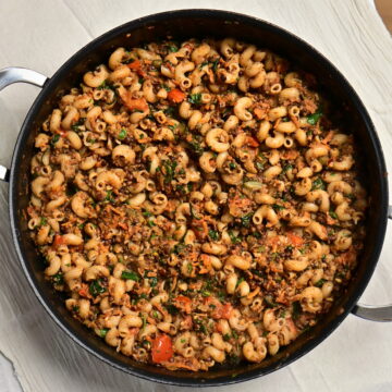 A pot of lentil and mushroom ragù with curly pasta.