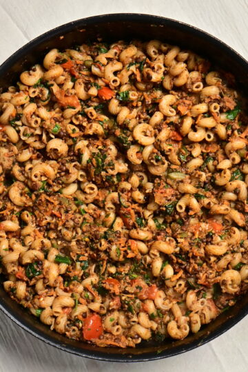 A pot of lentil and mushroom ragù with curly pasta.