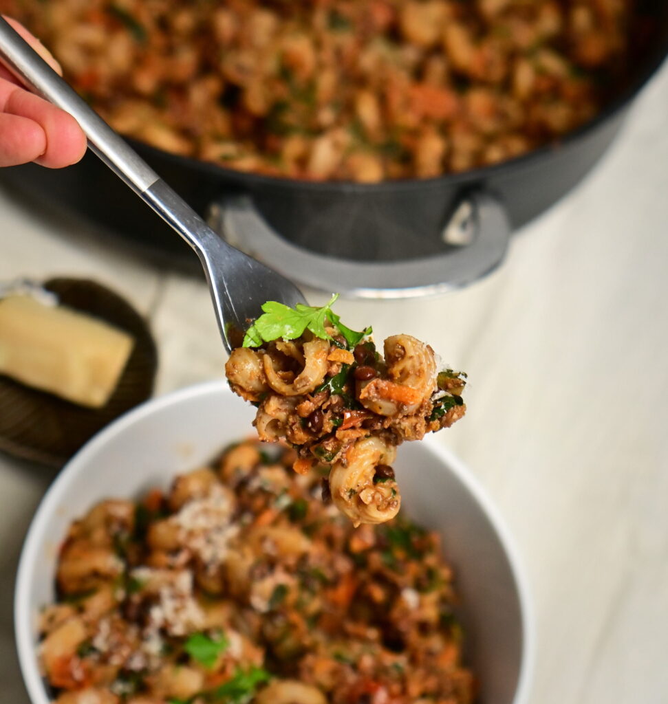 fork with lentil and mushroom ragù with curly pasta, over a pot