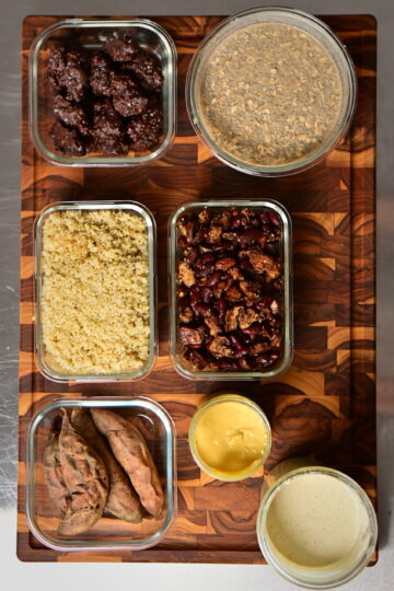 meal prep in glass containers over wooden cutting board