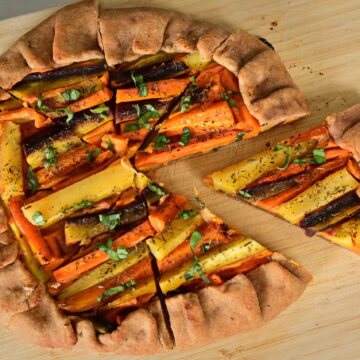 A colorful carrot galette on a wooden board.